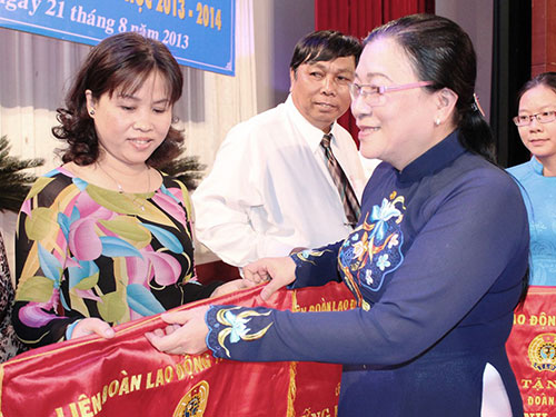 Bà Nguyễn Thị Bích Thủy, Phó Chủ tịch LĐLĐ TP HCM, trao cờ thi đua cho đại diện các tập thể xuất sắc của CĐ Giáo dục TP 
ẢNH: NGA HOÀNG