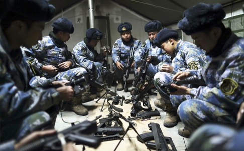 Binh sĩ PLA lau vũ khí tại một căn cứ quan sự. Ảnh: Reuters