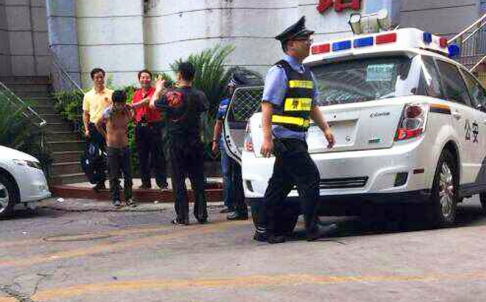 Một nghi phạm bị dẫn ra khỏi nhà nghỉ ở TP Thâm Quyến. ẢNh: SCMP