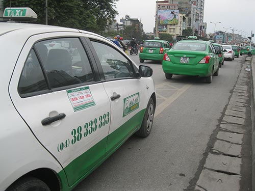 Đường tại Hà Nội đã quá chật chội và không đủ chỗ để cho 17.000 taxi hoạt động.  Trong ảnh: Hàng dài taxi đậu trước cổng Bệnh viện Bạch Mai Ảnh: NGUYỄN HƯỞNG