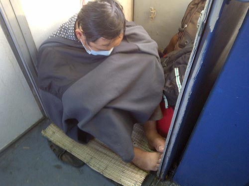Một hành khách ngủ gật gù ở gần tủ điện