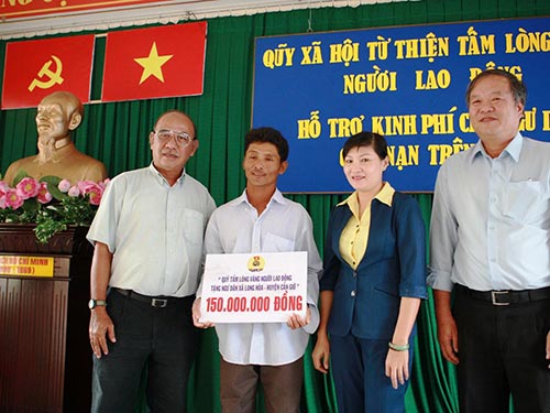 Ông Nguyễn Thọ Trung (trái), Phó Giám đốc Quỹ Tấm lòng vàng Người Lao Động, trao tiền cho ngư dân xã Long Hòa