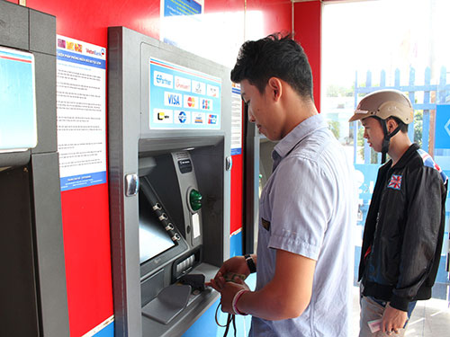 Khách hàng rút tiền qua hệ thống máy ATM. (Ảnh chỉ có tính minh họa) Ảnh: HOÀNG TRIỀU Khách hàng rút tiền qua hệ thống máy ATM. (Ảnh chỉ có tính minh họa) Ảnh: HOÀNG TRIỀU