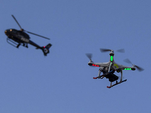 Trực thăng cảnh sát Mỹ bay phía trên một chiếc drone tại bang Maryland hồi tháng 5-2015 Ảnh: REUTERS