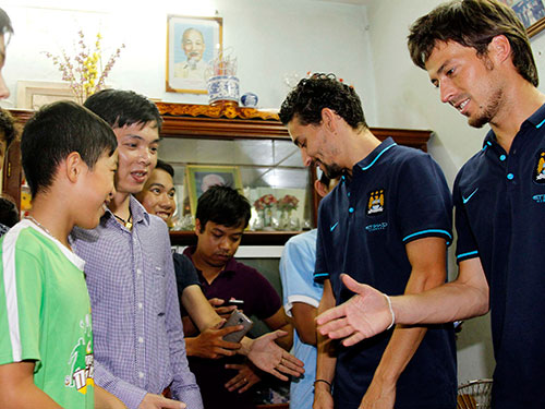 David Silva (phải) bắt tay CĐV “nhí” ở Làng trẻ SOS Ảnh: HẢI ANH