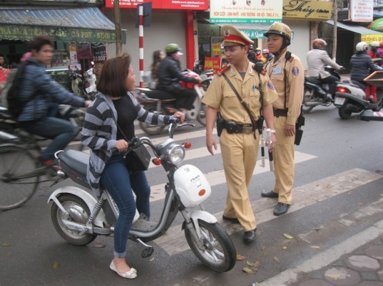 Yêu cầu người đi xe đạp điện không đội mũ bảo hiểm về vị trí xử lý vi phạm