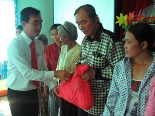 Ông Hoàng Xuân Lộc, Trưởng Văn phòng Prudential Việt Nam tại Đà Nẵng, trao quà cho người nghèo ở thị trấn Trà My Ảnh: PHƯƠNG THẢO