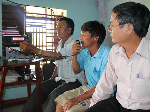 Qua bộ đàm Icom, ông Nguyễn Thanh Nam (bìa trái) nghe ngư dân thông báo tình hình tàu cá bị Trung Quốc tấn công