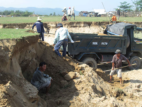 Khai thác đất cát rầm rộ ở bờ sông Vu Gia mà chính quyền địa phương gọi là “cải tạo đất” Ảnh: BÍCH VÂN