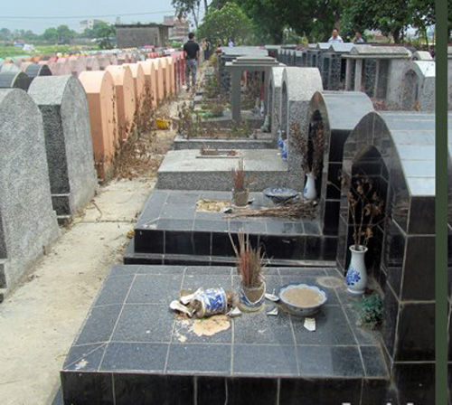 Những bát hương bị đập vỡ trong nghĩa trang - Ảnh: ANTĐ