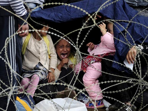 Một bé gái kêu khóc khi gia đình đang cố tiến qua biên giới Macedonia ngày 22-8 Ảnh: REUTERS