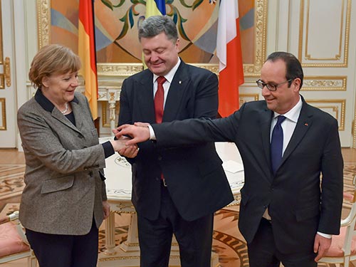 Tổng thống Ukraine Petro Poroshenko (giữa) bắt tay Thủ tướng Đức Angela Merkel và Tổng thống Pháp Francois Hollande trong cuộc họp ở Kiev hôm 5-2 Ảnh: REUTERS