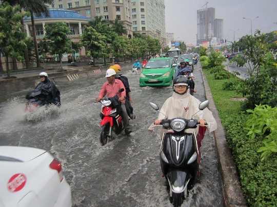 Người đi xe máy phải lưu thông trong làn đường ô tô để tránh nước ngập, gây nguy cơ xảy ra tai nạn giao thông rất cao