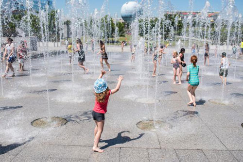 Trẻ em tránh nóng tại một đài phun nước ở thủ đô Paris - Pháp hôm 30-6  Ảnh: AP