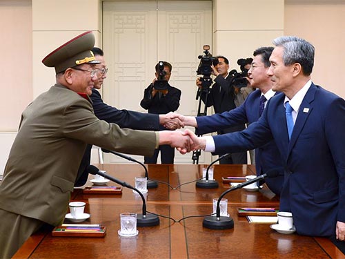 Cố vấn an ninh quốc gia Hàn Quốc Kim Kwan-jin (phải) và ông Hwang Pyong-so, phụ tá quân sự cấp cao của nhà lãnh đạo Triều Tiên Kim Jong-un, tại cuộc họp ngày 22-8 Ảnh: REUTERS