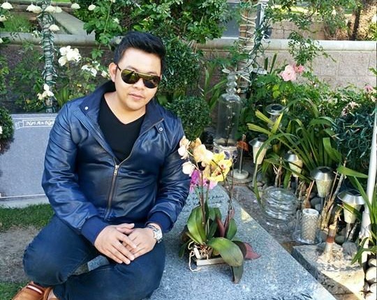 Ảnh Quang Lê ngồi trên mộ bị chỉ trích