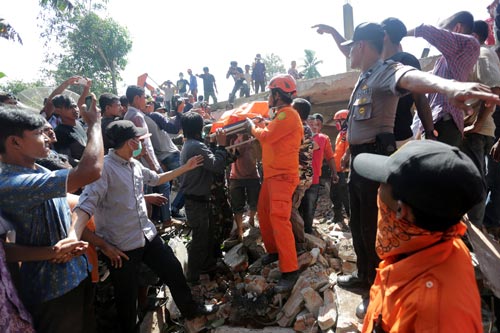 Lực lượng cứu hộ nỗ lực tìm kiếm các nạn nhân mắc kẹt ở khu vực Pidie Jaya, tỉnh Aceh - Indonesia hôm 7-12 Ảnh: Reuters