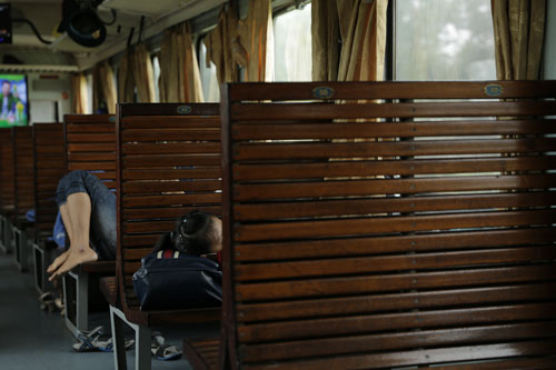 Các toa tàu vắng khách, nhiều hành khách thoải mái nằm ngủ trên băng ghế Ảnh: NGUYỄN TUẤN