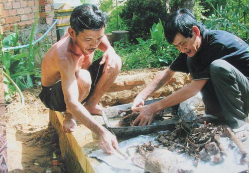 Ông Ba Oanh (phải) giúp hốt cốt cho những người có hoàn cảnh khó khăn. (Ảnh do gia đình cung cấp)