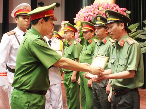 Đại tá Đinh Thanh Nhàn, Phó Giám đốc Công an TP HCM, trao giấy khen cho các tập thể, cá nhân có thành tích xuất sắc trong Phong trào Toàn dân bảo vệ an ninh Tổ quốc
