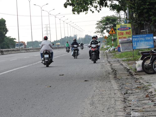 Đất đá rơi vung vãi đầy Quốc lộ 51 “gài bẫy” người đi đường (ảnh trên) và nhiều người xem quốc lộ như đường làng nên vô tư chạy ngược chiều