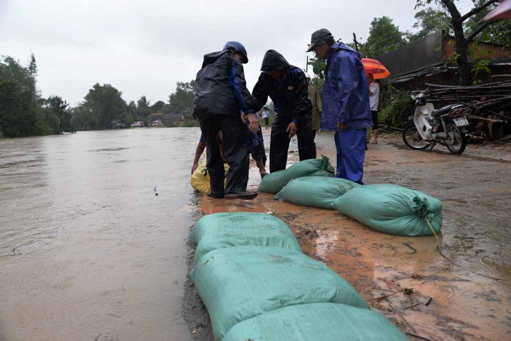  Lực lượng chức năng d&ugrave;ng bao c&aacute;t chặn kh&ocirc;ng cho lũ tr&agrave;n qua bờ bao dọc theo s&ocirc;ng Tr&agrave; C&acirc;u, Đức Phổ (Quảng Ng&atilde;i). Ảnh: Tử Trực 