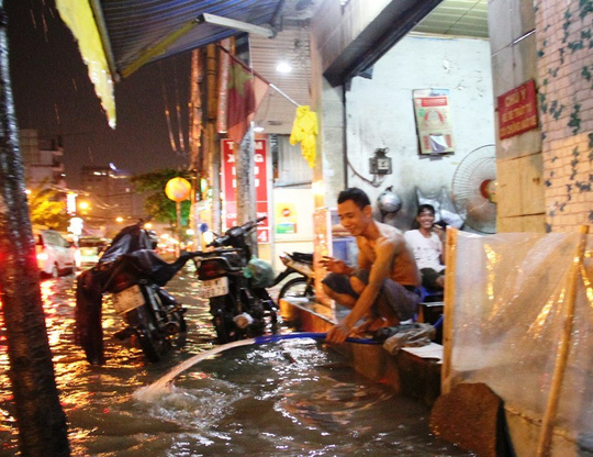 
Một hộ dân phải dùng vòi bơm nước ra ngoài do bị tràn vào nhà
