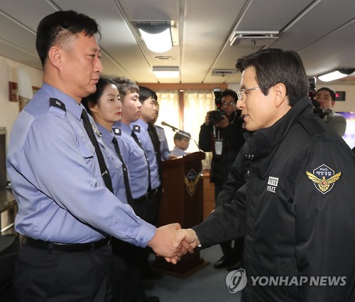 Ông Hwang bắt tay lực lượng bảo vệ bờ biển trên tàu tuần tra đậu ở bến tàu Incheon. Ảnh: YONHAP