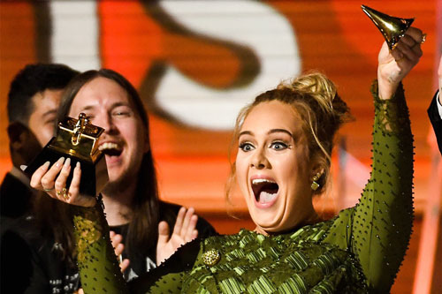 Adele phấn khích, bẻ tượng kèn vàng như muốn chia đôi giải thưởng Trình diễn nhạc pop xuất sắc nhất của mình cho Beyoncé khi nhận giải trên sân khấu trao giải Grammy 59 Ảnh: GRAMMY