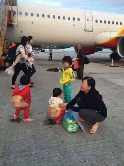 
Người phụ nữ tươi cười khi cho các cháu nhỏ tè bậy ở sân bay Ảnh: FACEBOOK
