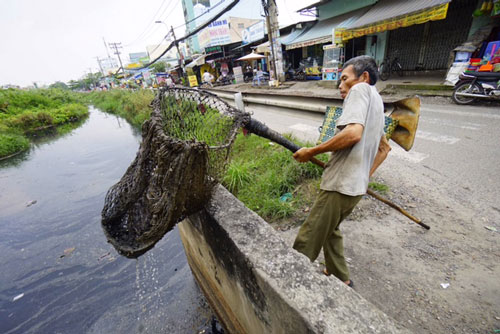 Mỗi ngày có hàng triệu người đang thầm lặng làm những việc tốt. Trong ảnh: Ông Nguyễn Ngọc Đức hằng ngày vớt rác làm sạch kênh Chiến Lược (quận Bình Tân, TP HCM) Ảnh: HOÀNG TRIỀU