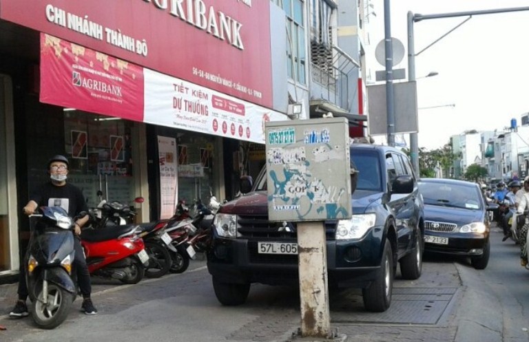 
Xe ô tô đậu trên vỉa hè trước một quán cà phê buộc người đi bộ phải đi ngay dưới đường

