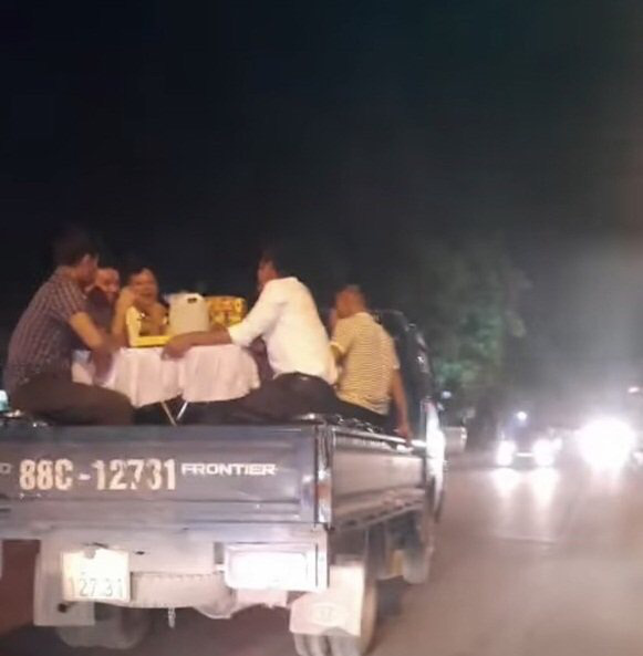 Xử phạt tài xế chở người cùng ghế, bàn phủ vải trắng trên thùng xe tải đi ăn cưới - Ảnh 1. Xử phạt tài xế chở người cùng ghế, bàn phủ vải trắng trên thùng xe tải đi ăn cưới - Ảnh 1.