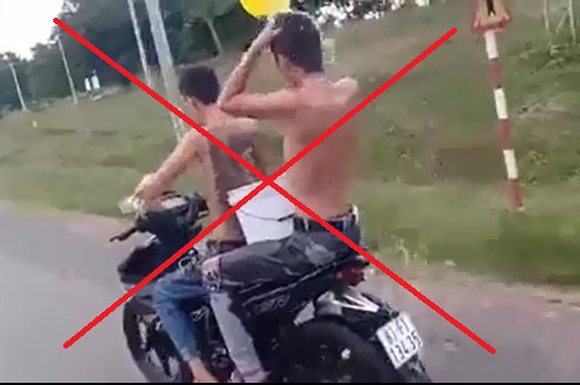Vừa đi xe máy vừa tắm, 2 thanh niên bị phạt - Ảnh 1.