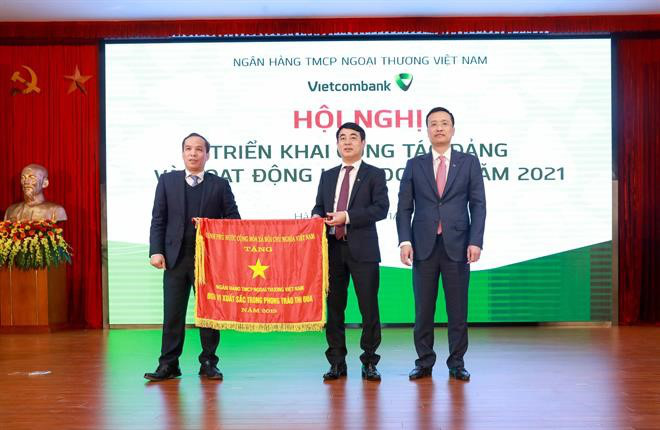 Thừa ủy quyền của Thủ tướng Chính phủ, Phó Thống đốc NHNN Đoàn Thái Sơn (bìa trái) trao Cờ thi đua của Thủ tướng Chính phủ cho Vietcombank