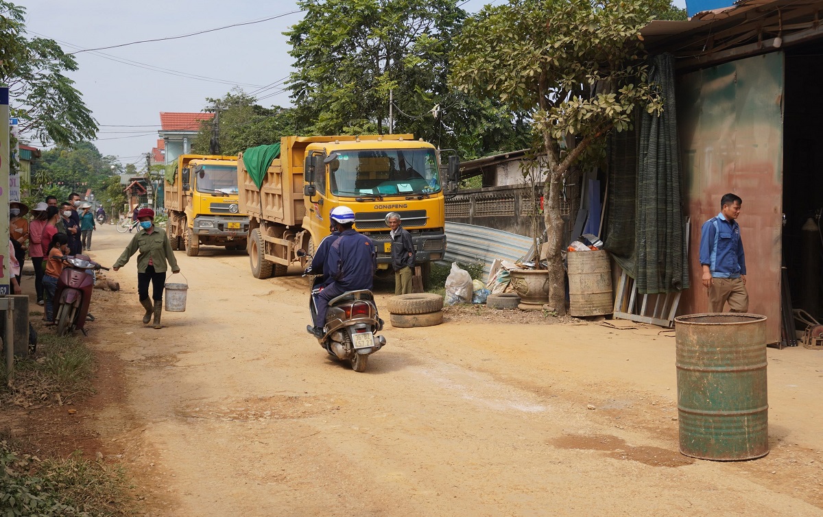 Dân mang thùng phuy, khúc gỗ... chặn đoàn xe tải chở đất - Ảnh 1.