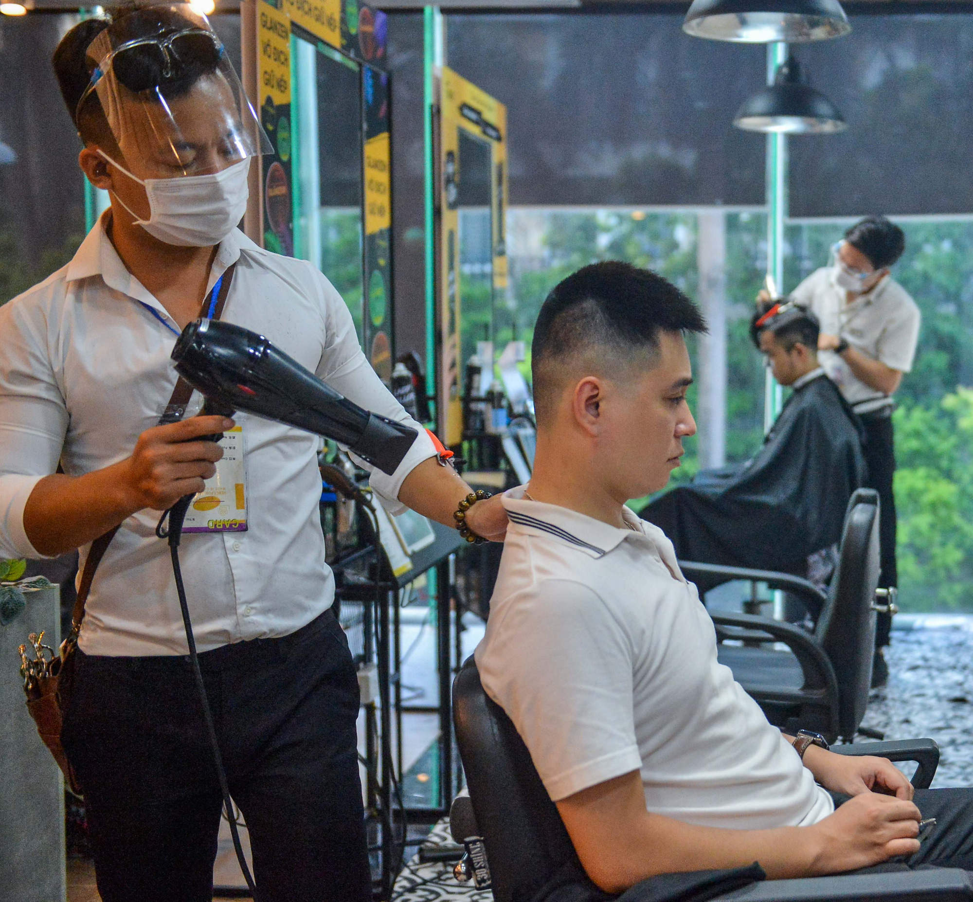 Người dân chờ hàng tiếng đồng hồ để cắt tóc trước “giờ G” - Ảnh 6.