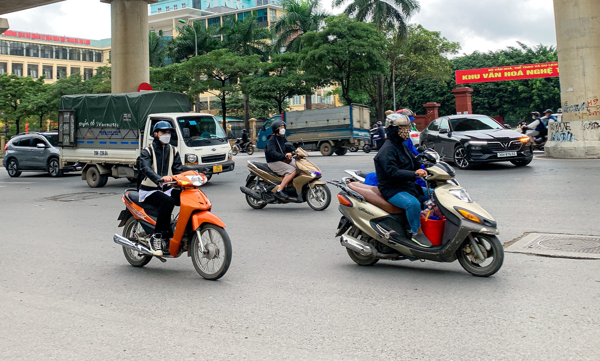 Người dân Hà Nội trùm áo mưa đón không khí lạnh - Ảnh 1.