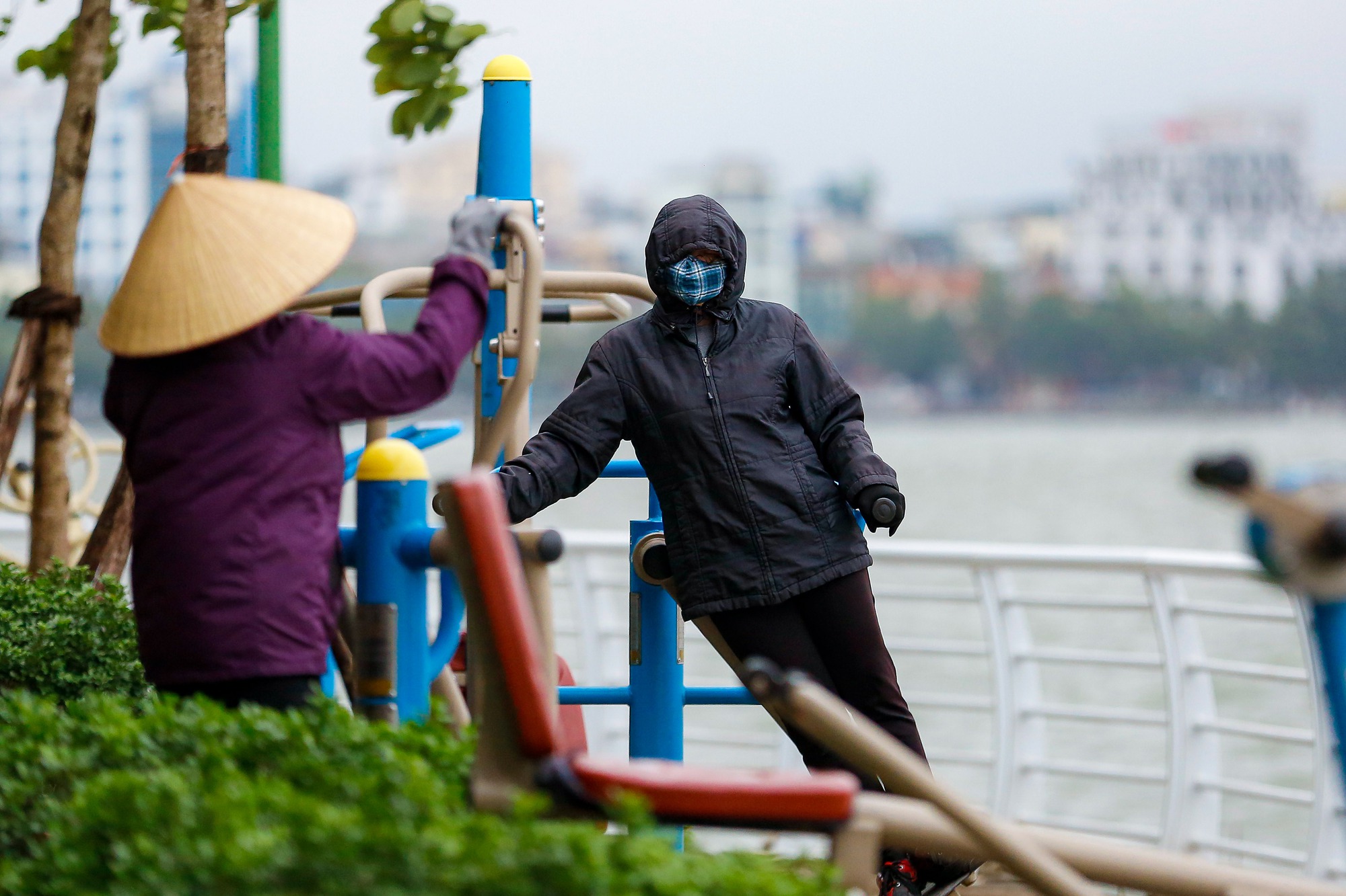 Người dân Hà Nội trùm áo mưa đón không khí lạnh - Ảnh 10.