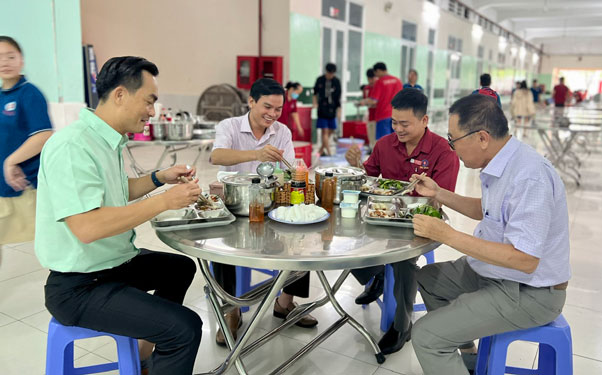 Ông Phan Ngọc Liêm, Tổng Giám đốc Công ty CP Dịch vụ - Giáo dục Trí Đức (bìa trái), dùng cơm trưa cùng người lao động