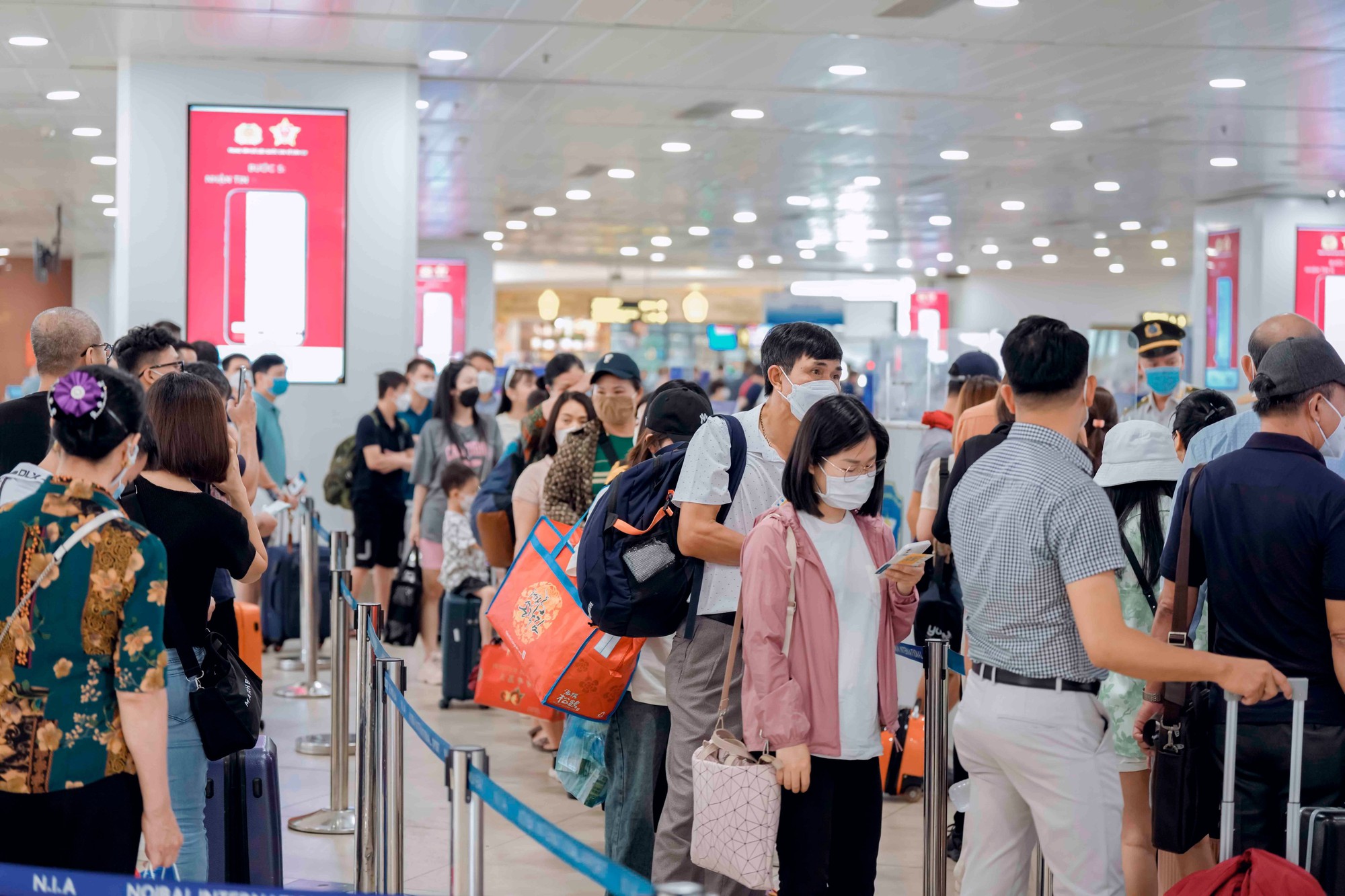 Khách ùn ùn qua sân bay, nâng mức kiểm soát an ninh hàng không - Ảnh 1.