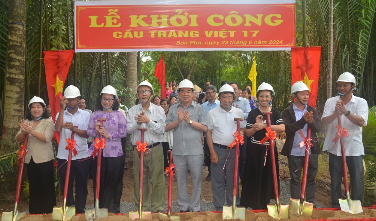 A group of people standing under a sign  Description automatically generated