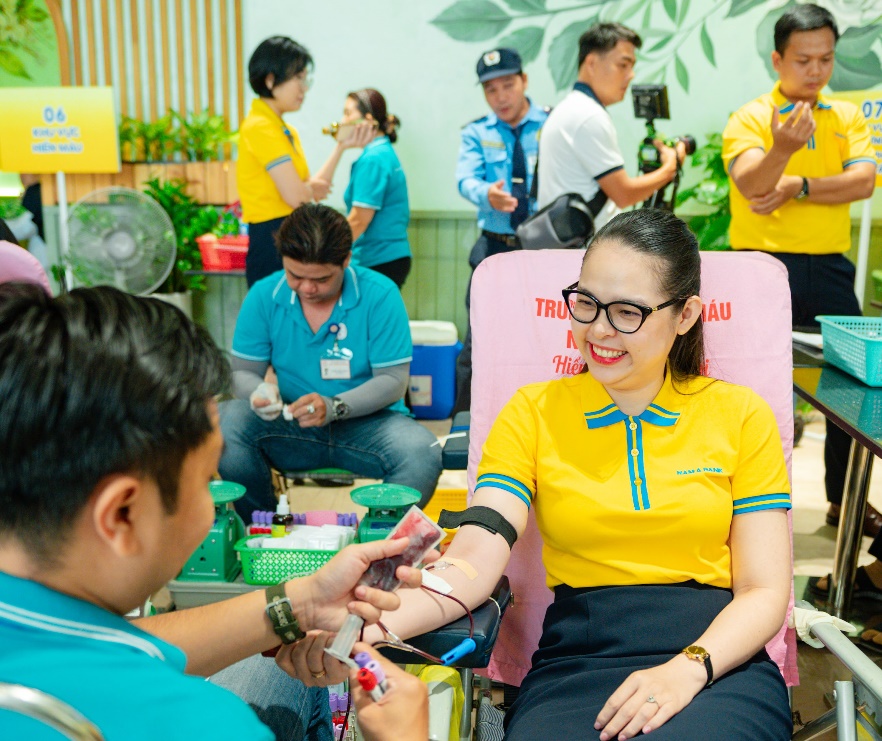 A person in a chair with a person in a yellow shirt  Description automatically generated