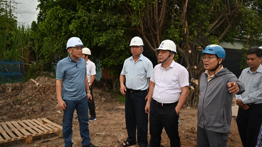 A group of men wearing hard hats  Description automatically generated