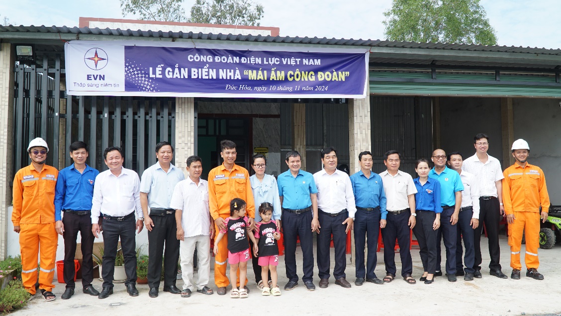 A group of people standing in front of a building  Description automatically generated