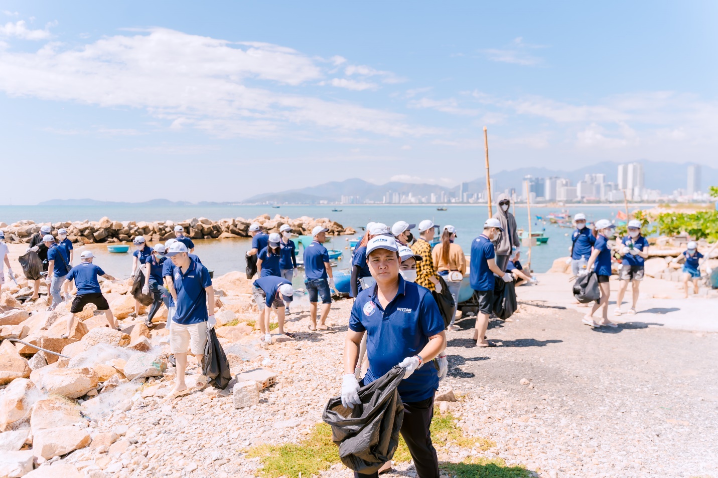 A group of people in blue shirts and white hats  Description automatically generated