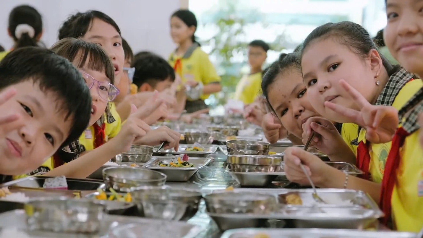 A group of children eating at a table  Description automatically generated