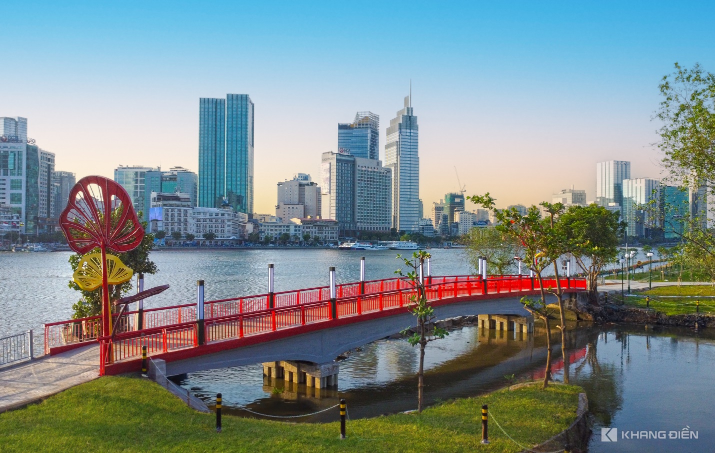 A bridge over water with a city in the background  Description automatically generated