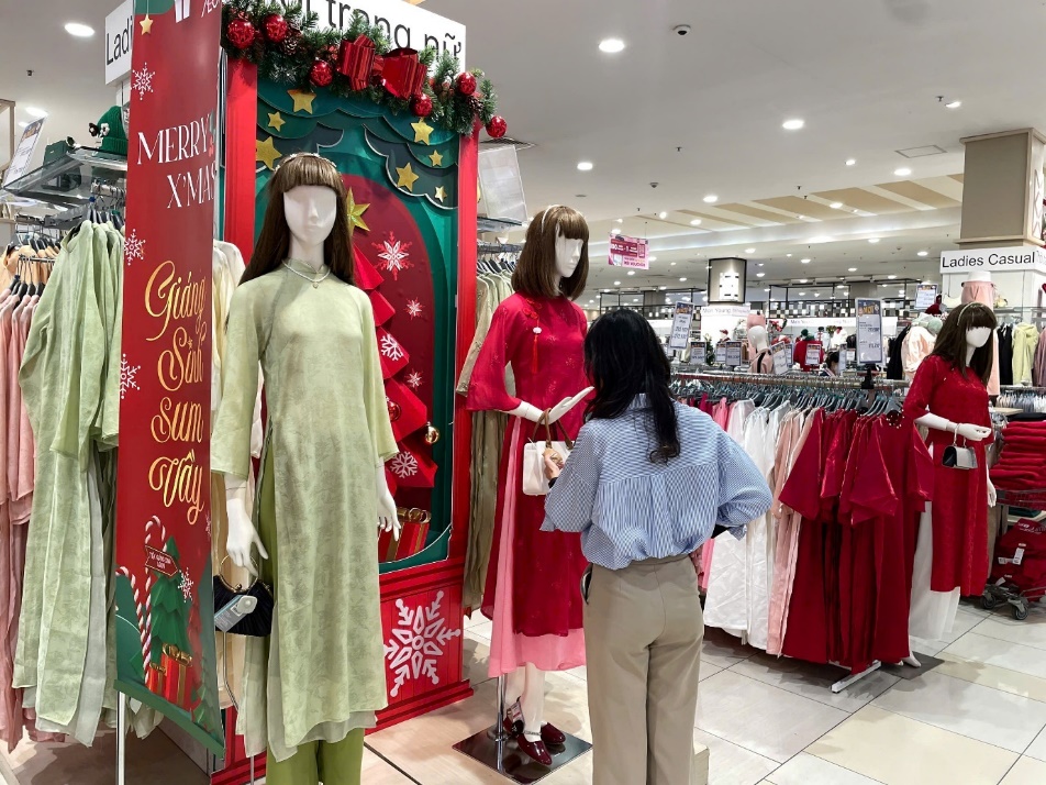 A person standing in front of a store with mannequins  Description automatically generated