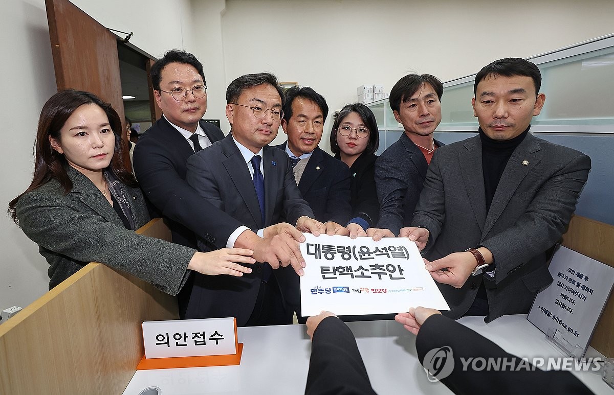 Lawmakers of the main opposition Democratic Party and other minor opposition parties submit a bill to impeach President Yoon Suk Yeol to the bills office at the National Assembly in Seoul on Dec. 4, 2024. (Yonhap)